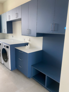 a kitchen with blue cabinets and a washer and dryer