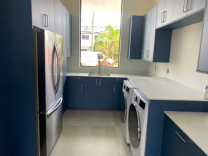 a kitchen with blue cabinets and a washer and dryer