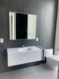 a modern bathroom with a sink, mirror, and toilet