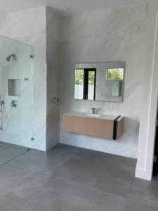 a glass enclosed shower and a sink in a palm beach county bathroom