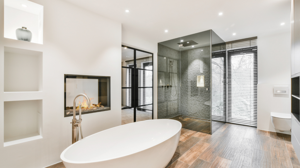 Modern bathroom with a freestanding bathtub, glass shower, and built-in fireplace for a luxurious and cozy atmosphere.