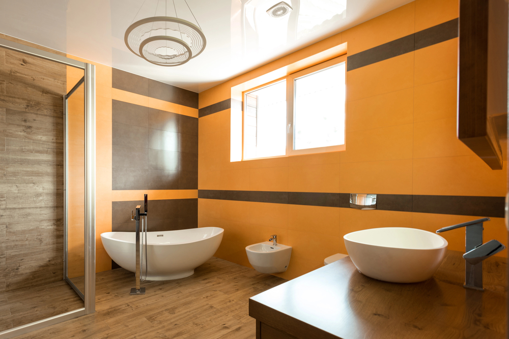 A modern bathroom with gold-like walls and modern features, exhibiting the benefits of a bathroom remodel.