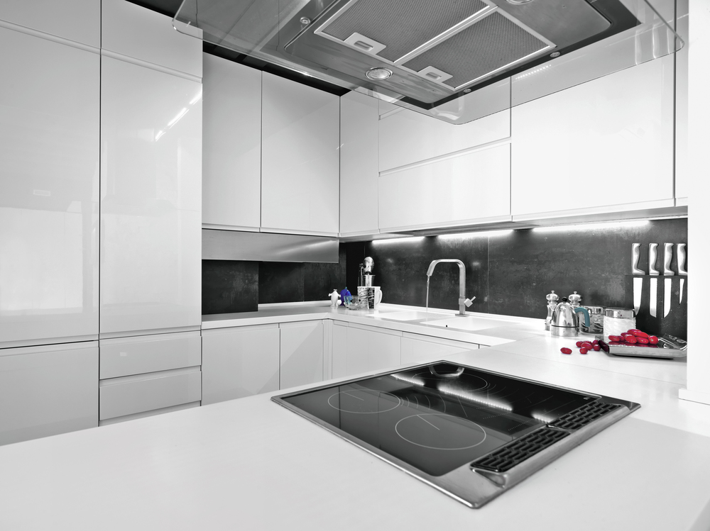 A modern kitchen with white cabinets and a black backsplash as part of the 2025 kitchen design trends.