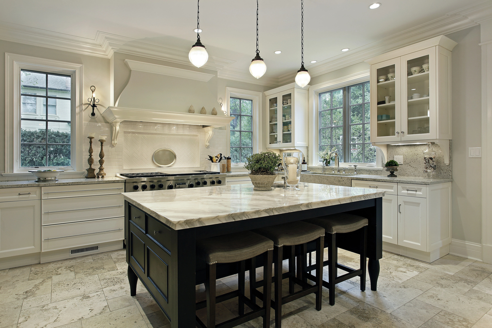 A brightly lit kitchen with hanging lights and white cabinetry, as part of the 2025 kitchen design trends.