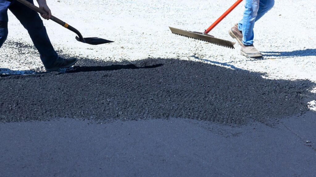 Two Workers Paving An Asphalt Driveway