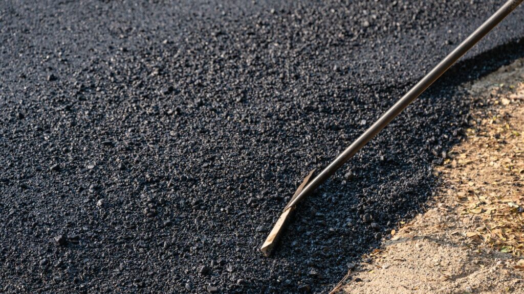 A Worker Paving An Asphalt Driveway